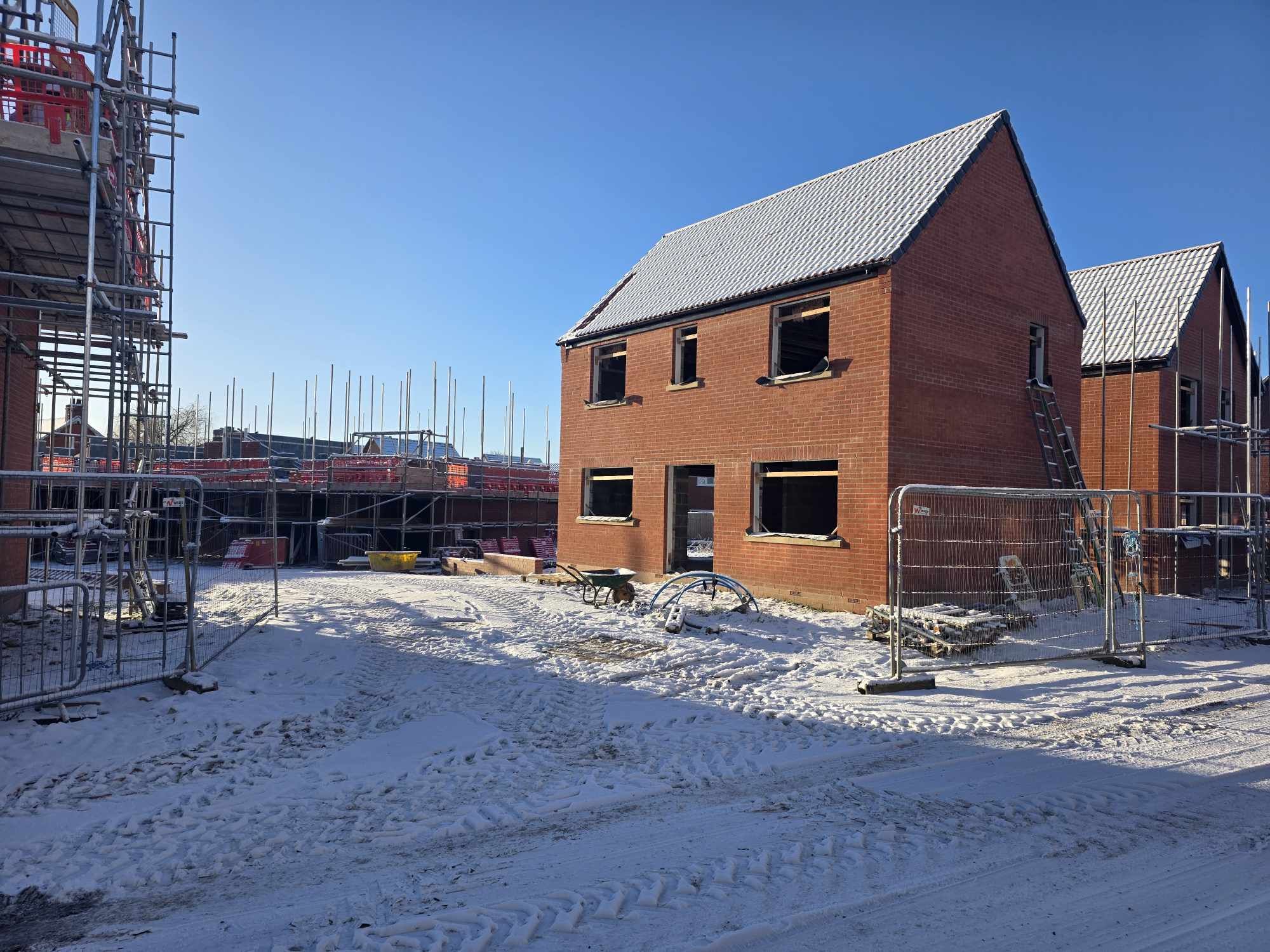 New-build housing plots in brick under snow